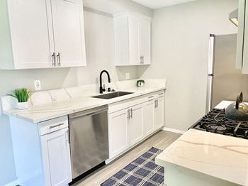 a kitchen with white cabinets and a stainless steel refrigerator at BLVD Apartments LLC, California